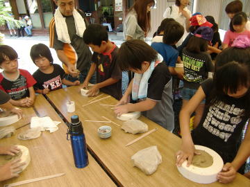 力を込めて、石膏型に粘土を押し込む小学生。