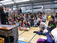 温室の中で楽しい読み聞かせに聞き入る子どもたち